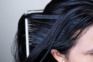 Close-up of black hair getting combed